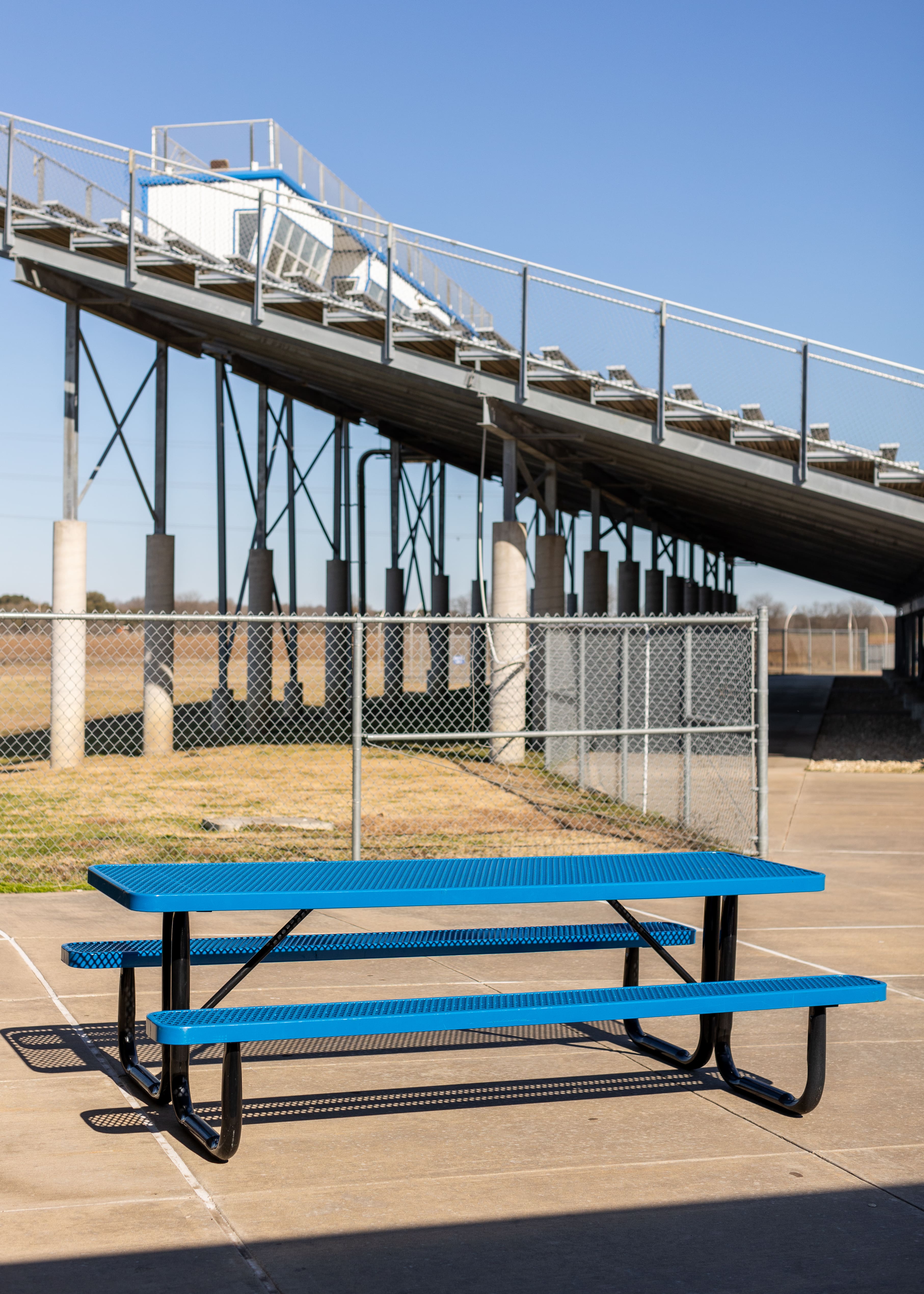 Blue MyTCoat Rectangular Portable Picnic Table Beside Tall Bleachers Lifestyle Image