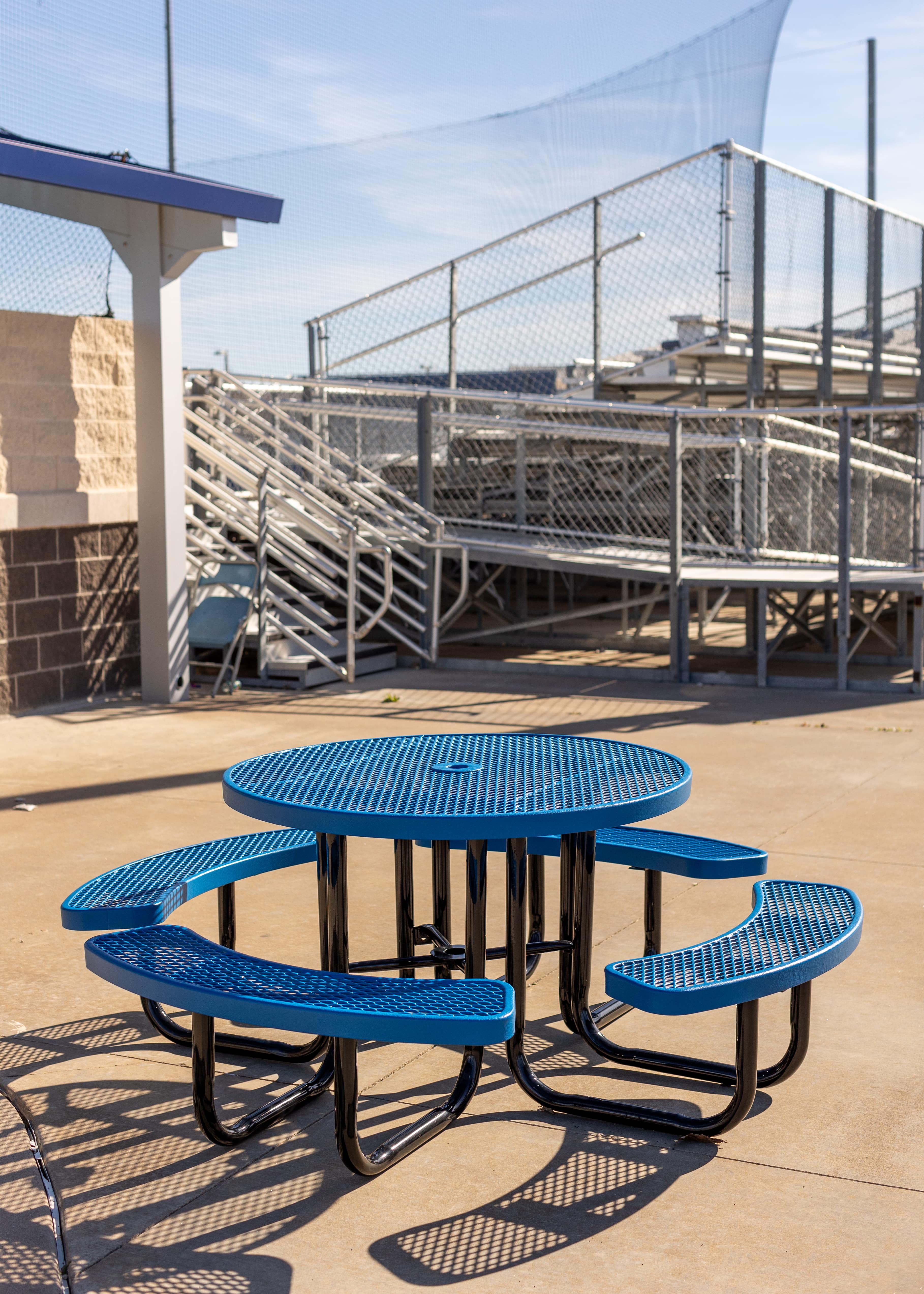 Blue MyTCoat Round Portable Picnic Table Lifestyle Image in School Courtyard