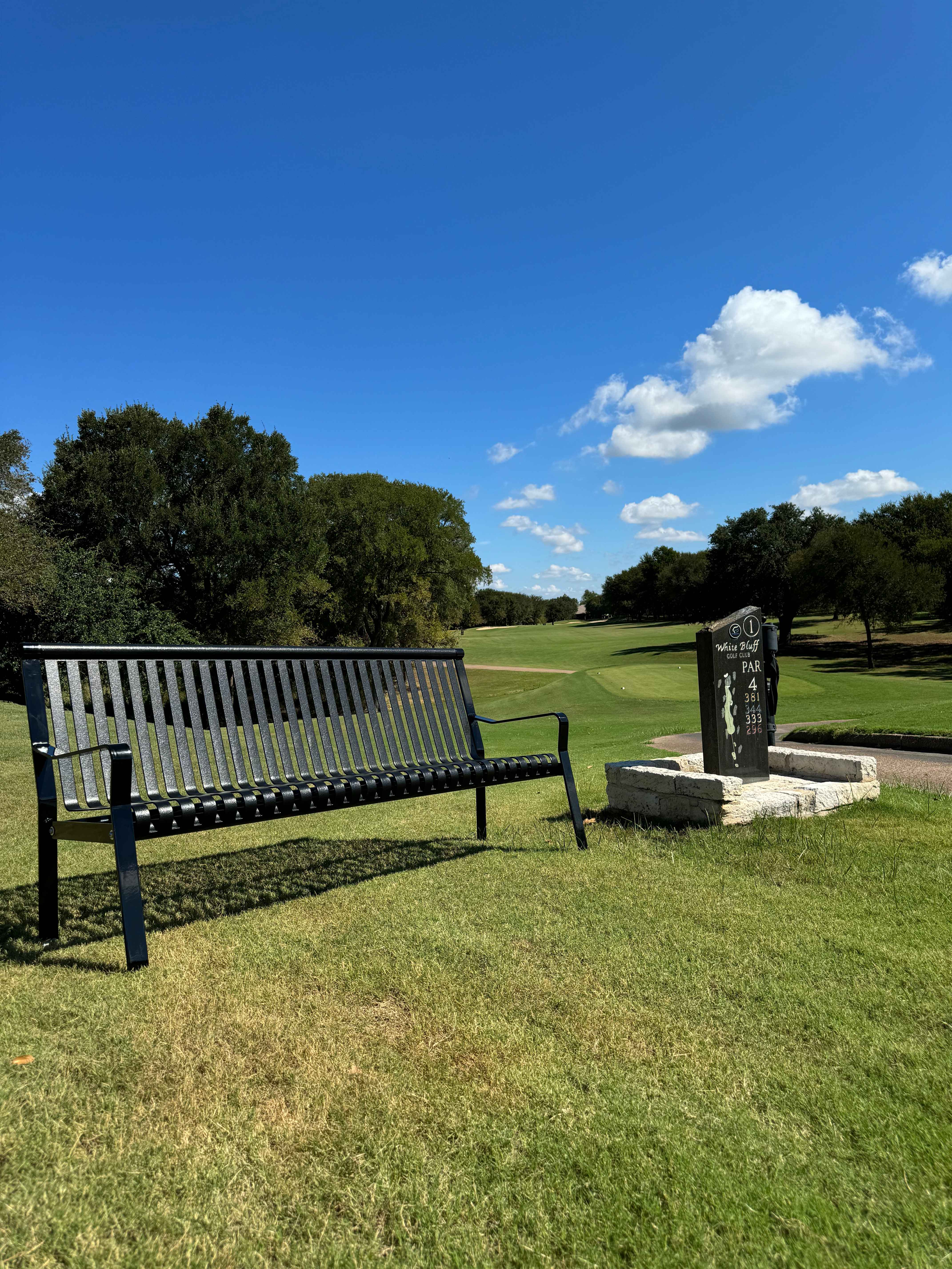 MyTCoat Metal Downtown Park Bench with Back Lifestyle Image with Golf Course Background