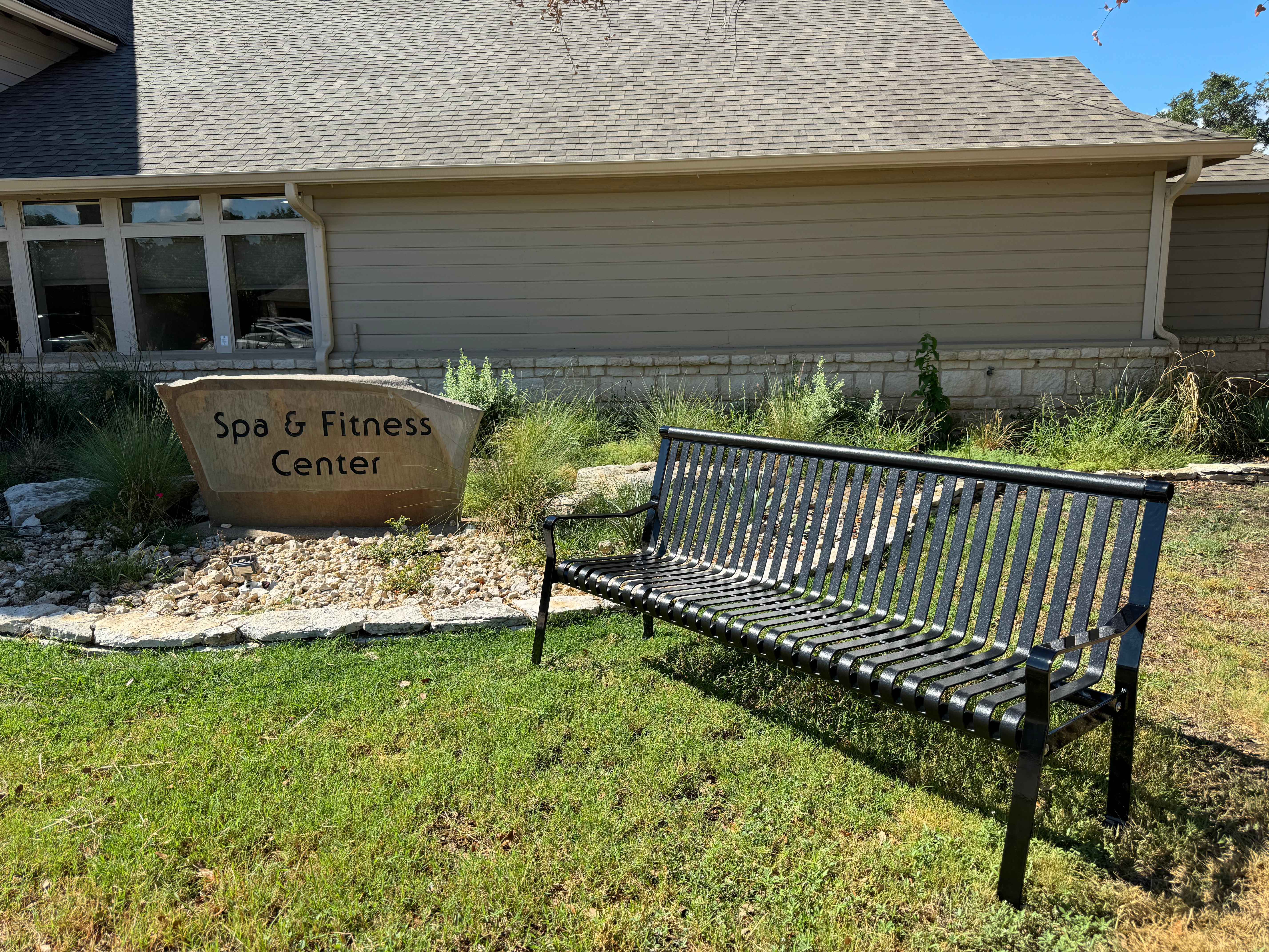 MyTCoat Metal Downtown Park Bench with Back Lifestyle Image with Spa And Fitness Center Background