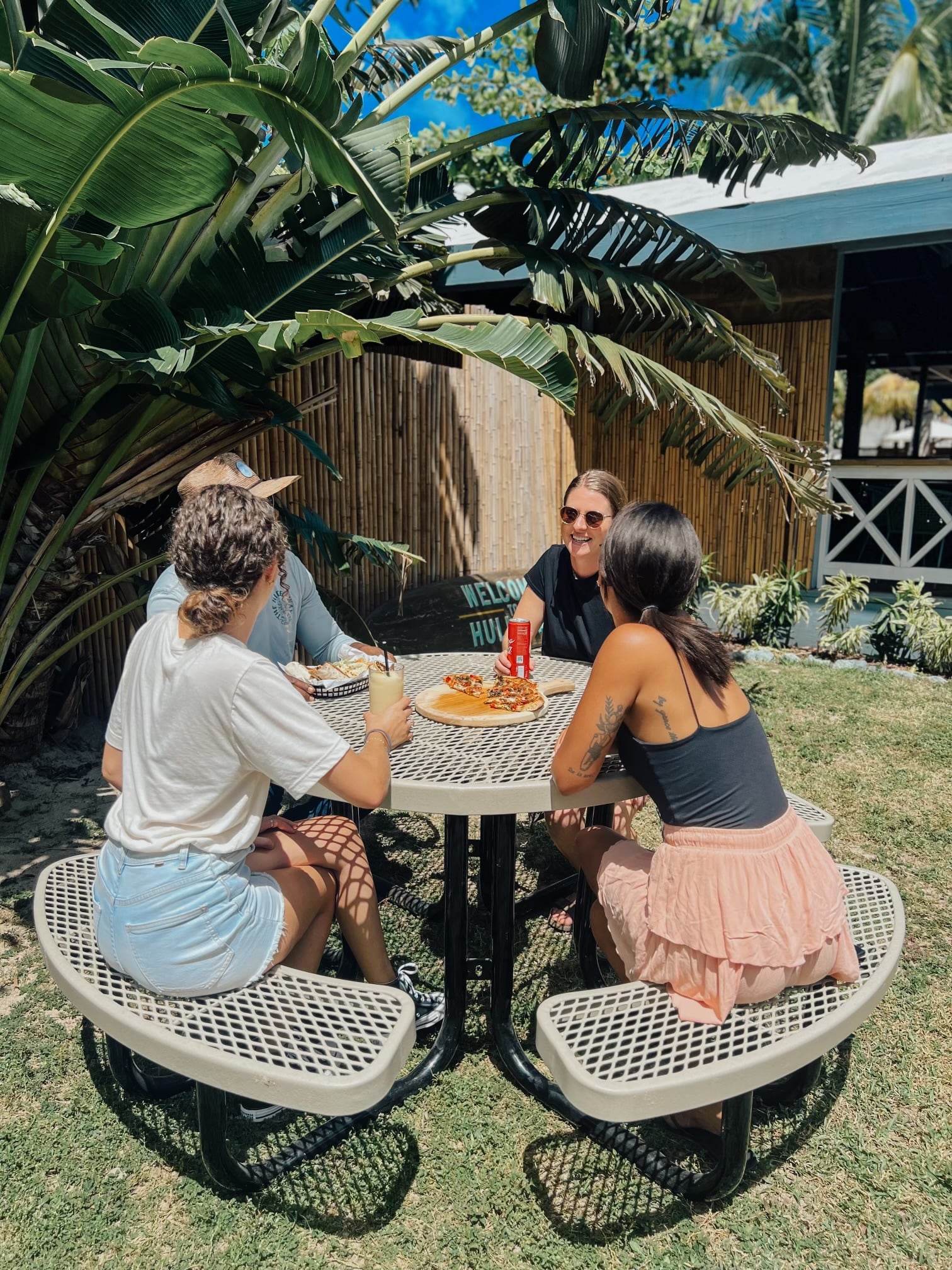 Tan MyTCoat Round Portable Picnic Table Lifestyle Image wit Garden Background and People Sitting
