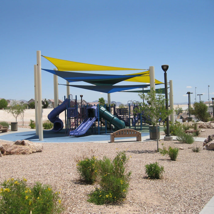 Sail shade canopies over a children's playground with slides