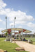 USA Shade Panorama Cantilever Covered area with sports equipment on a grassy field under a blue sky with clouds.