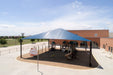 Playground with blue USA Shade Super Span Hip and basketball hoop in front of a building