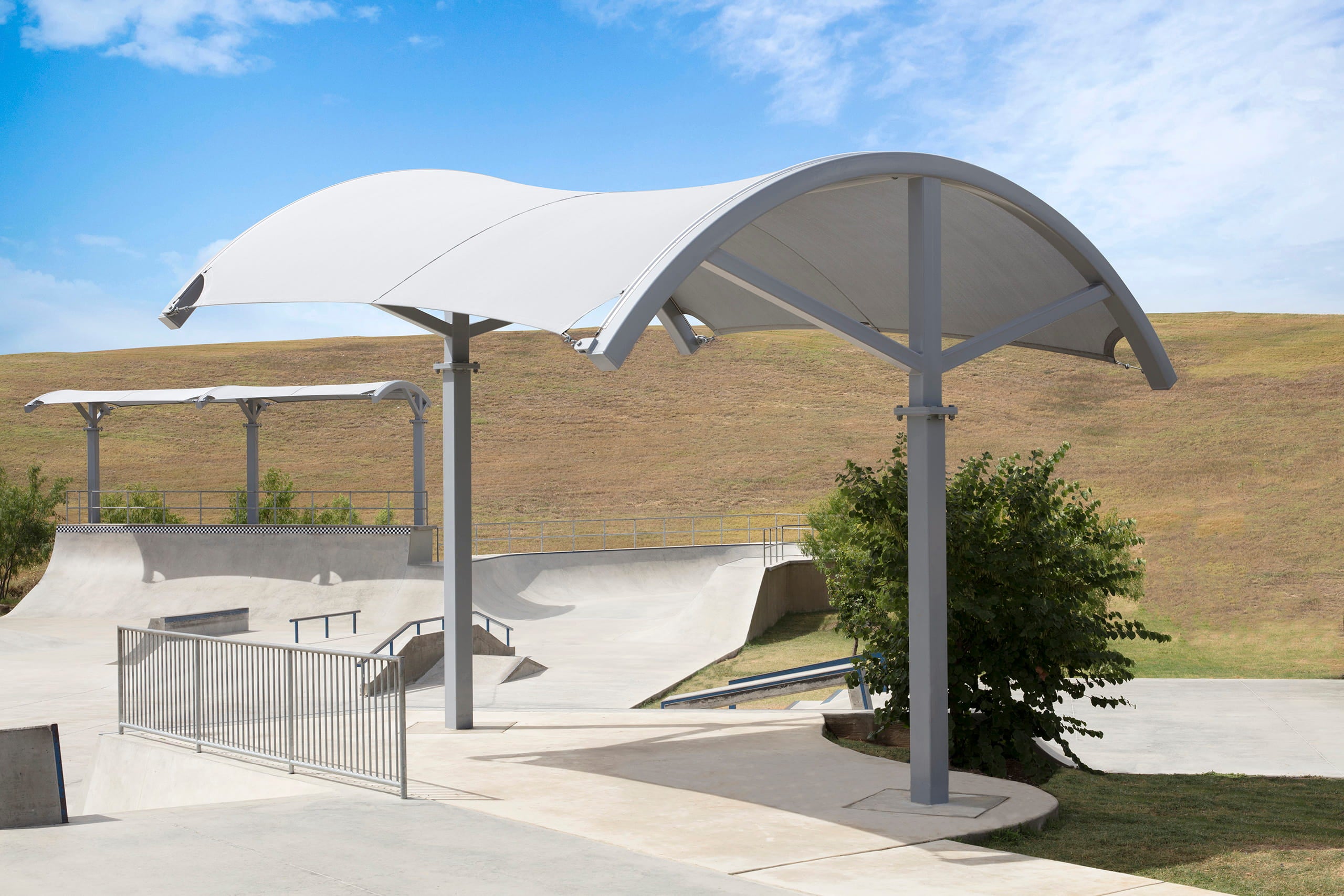Covered outdoor area with a large USA Shade Panorama Cantilever in a park setting
