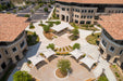 Aerial view of a courtyard with buildings and USA Shade Solana Cantilevers outdoor seating area.