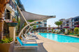 Pool area with lounge chairs and modern buildings in the background