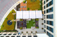 Top-down view of a building with a rooftop garden and outdoor area with a USA Shade Slanted Cantilever Cabled