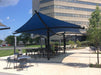 Outdoor seating area with blue USA Shade Aquarius Shade in front of a building