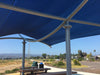 Bottom of Blue USA Shade Aquarius Shade with metal support structure over a picnic area with benches and trash cans.