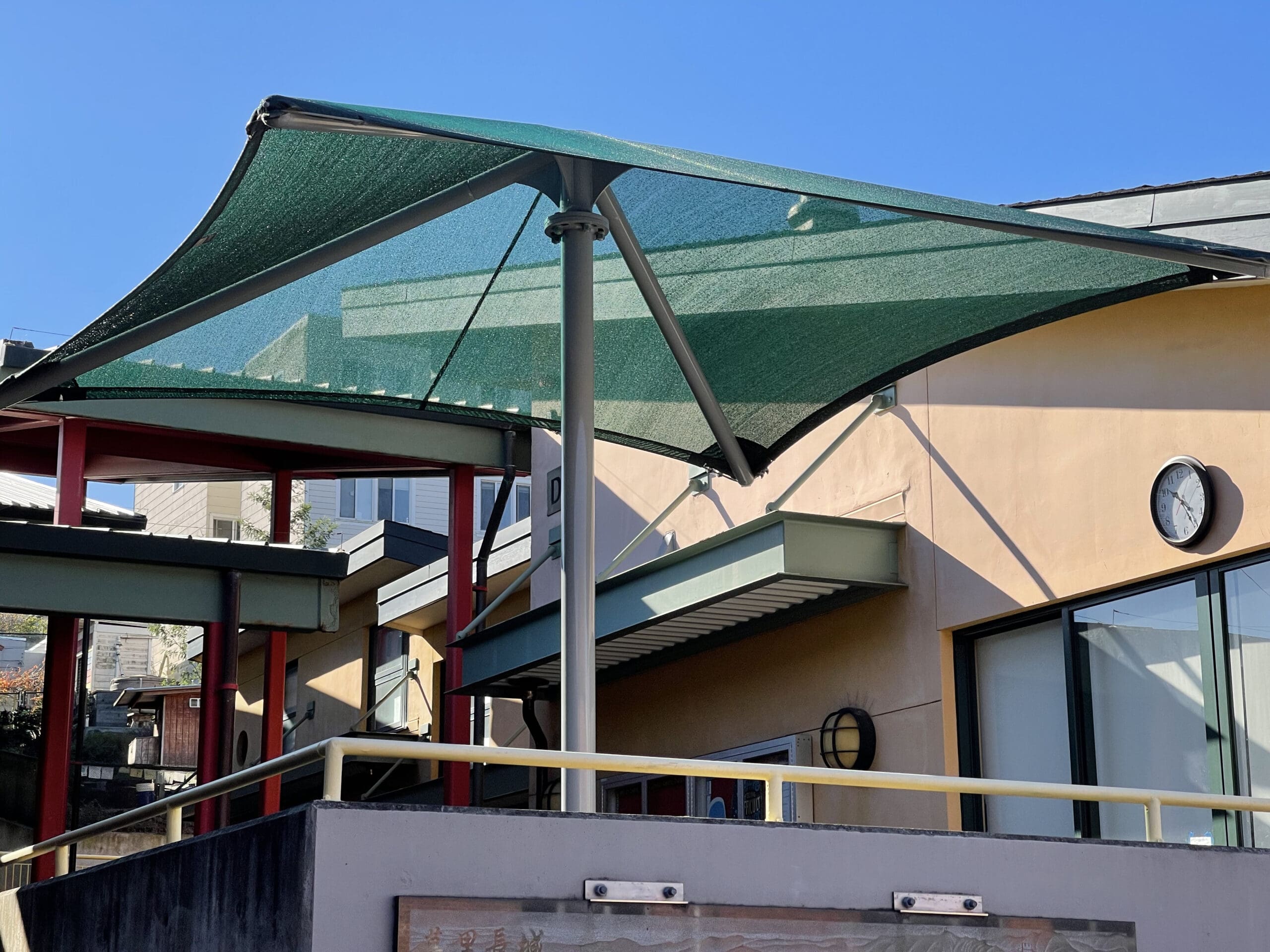Green Single post pyramid over a resaurant Building entrance with a clear blue sky