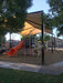 Playground with slides and a large USA Shade Super Span 6-Post Hip providing shade