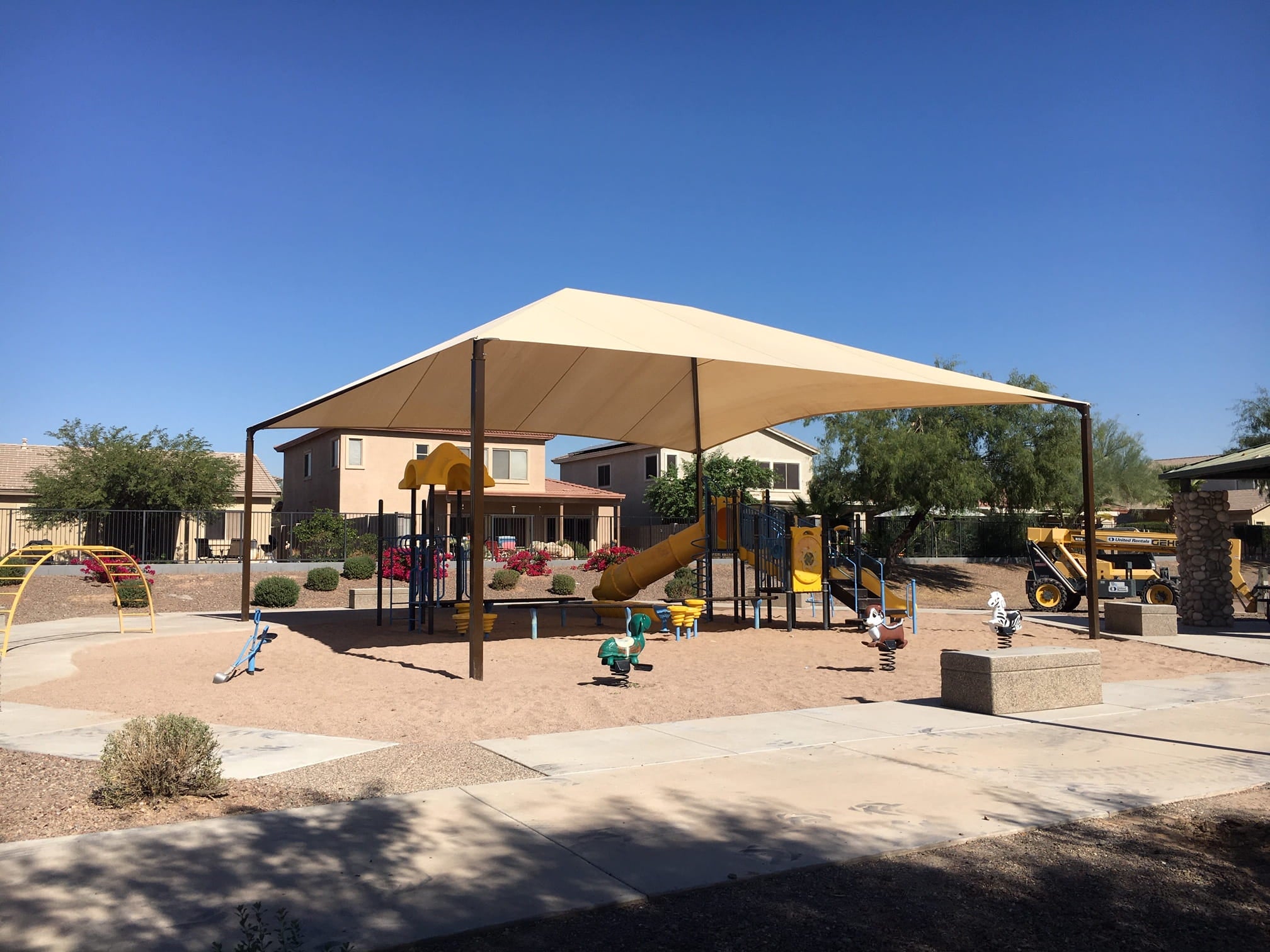 Children's playground with a large beige USA Shade Super Span Hip on a clear day.