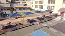 School playground with blue USA Shade Single Post Cantilever Shade Structures, basketball hoop, and outdoor furniture.