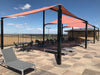 Outdoor patio area with red USA Shade Wave Shades, tables, and chairs on a sunny day.