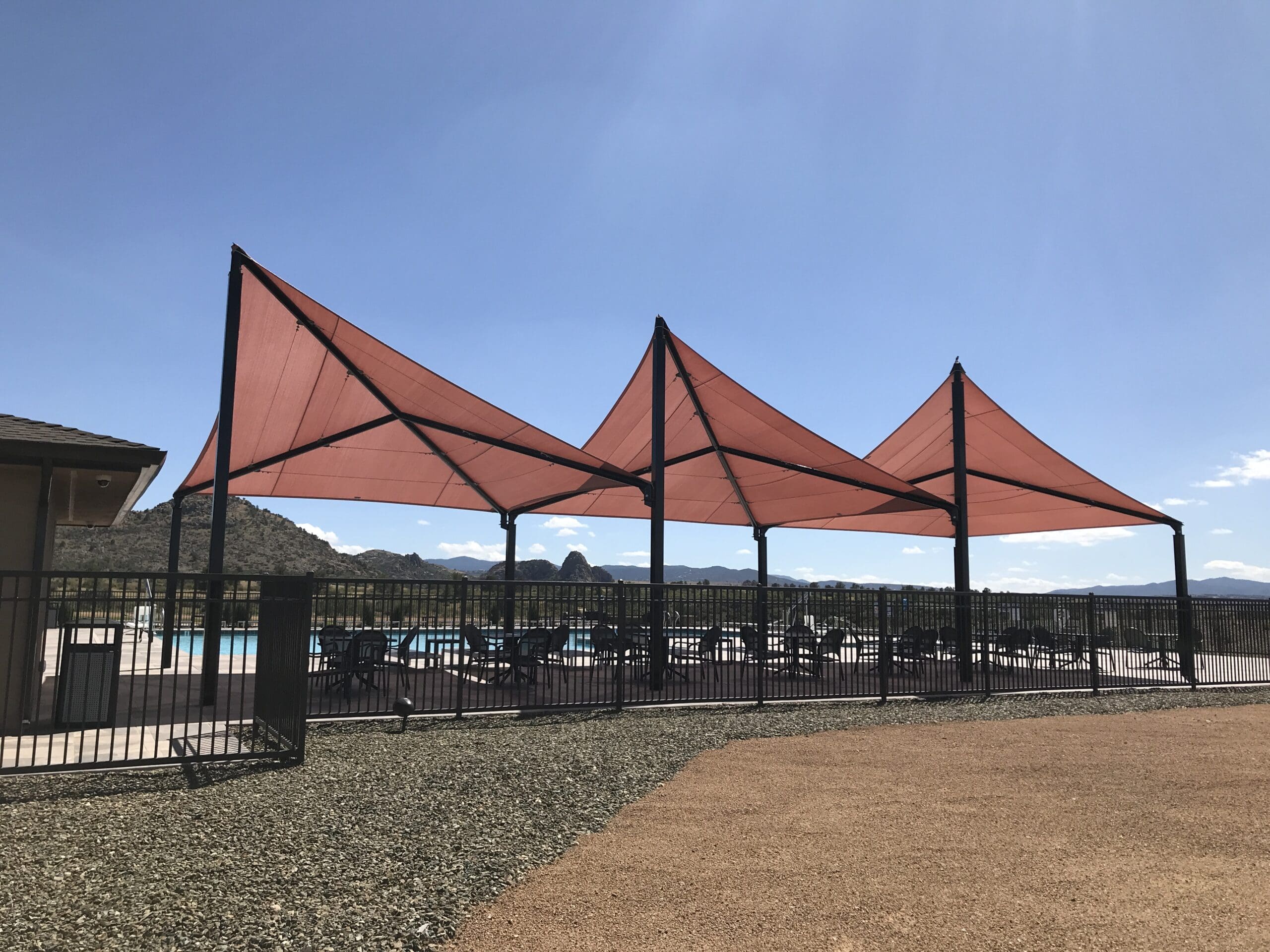 Three red USA Shade Wave Shades on a sunny day with mountains in the background.