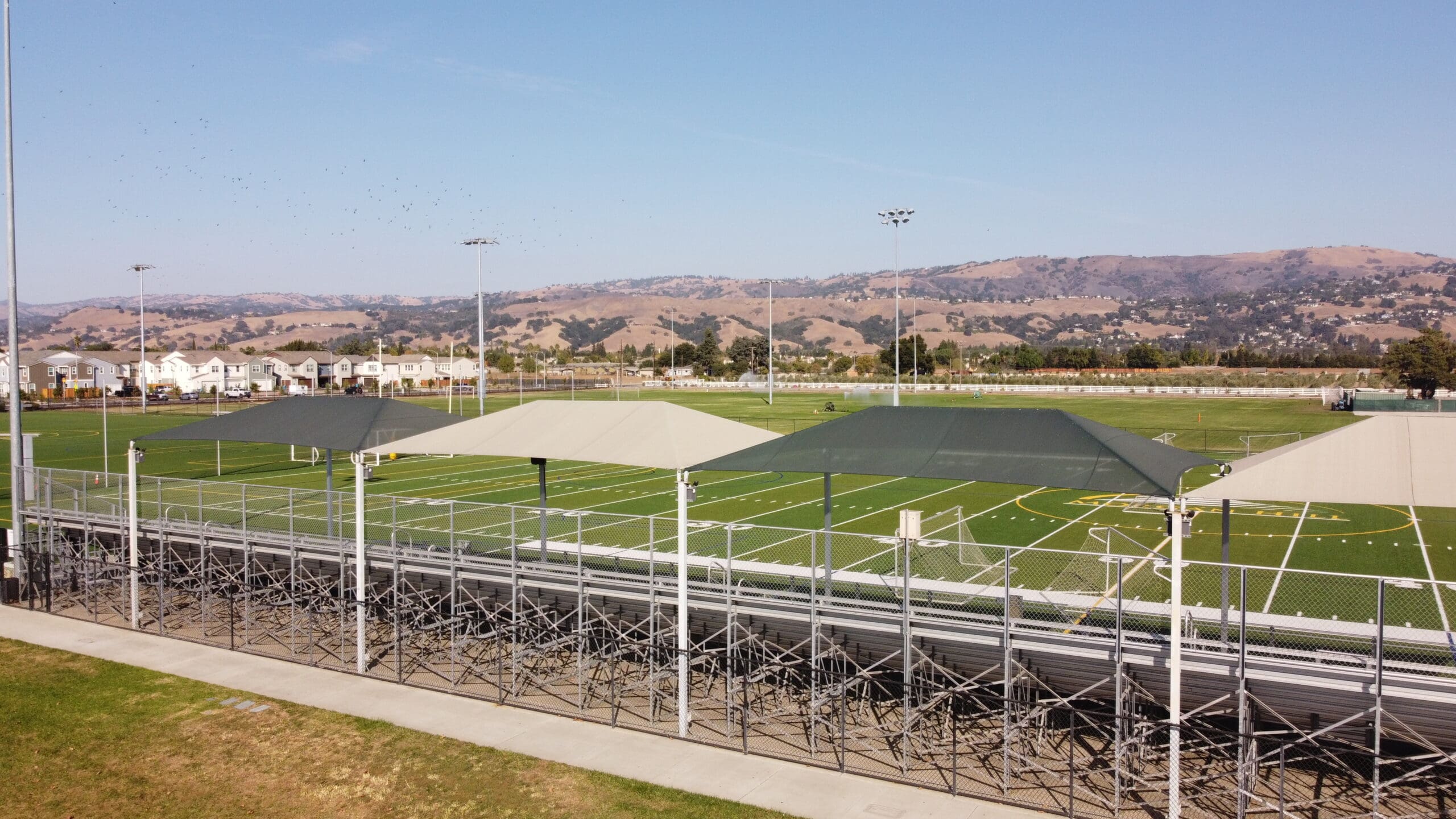 Outdoor sports facility with green USA Shade Hips and clear blue sky