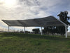 Solar panel USA Shade Slanted Cantilever Cabled structure in an outdoor setting with trees and grass.
