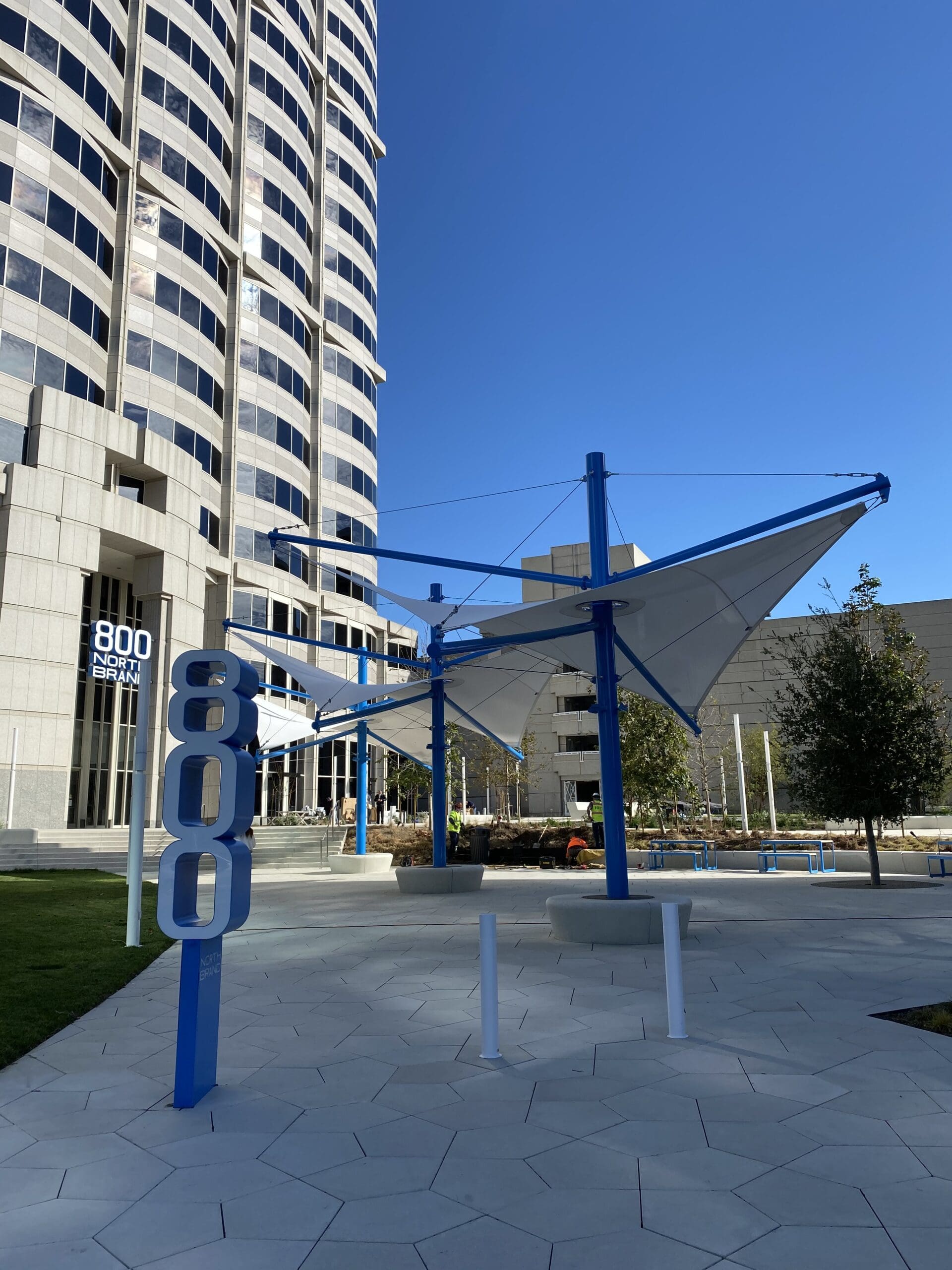 Blue and white USA Shade Aurora Shade in front of a tall building with '800' branding.