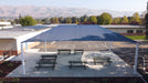 Outdoor covered area with USA Shade Hips with picnic tables in a school setting