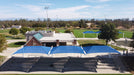Outdoor sports facility with blue USA Shade Full Hip Cantilever Shades and a building in the background