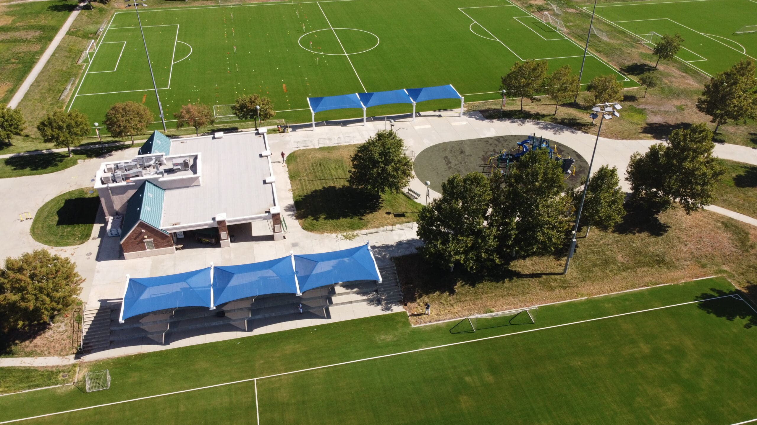 Aerial view of a sports complex with multiple fields and covered areas with USA Shade Full Hip Cantilever Shades.