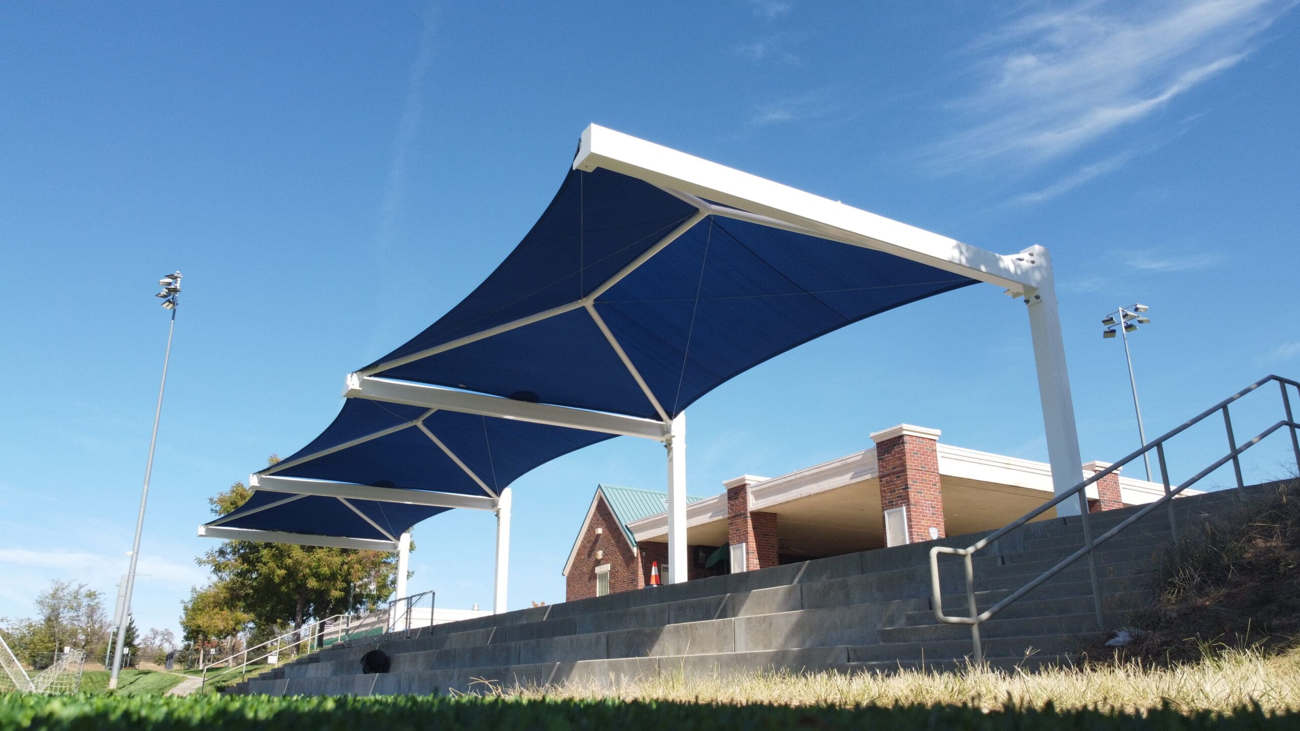 Blue USA Shade Full Hip Cantilever Shades with white frame against a clear blue sky