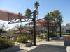 Outdoor red USA Shade Tri-Truss Cantilevers in a park-like setting with trees and buildings in the background.