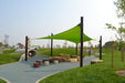 Children's playground with green 5-point shade sail and various play equipment on a grassy area.