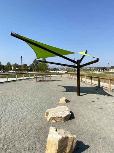 Green USA Shade Arbor Shade sail over a pathway with rocks and a clear blue sky