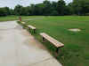 Black Wabash Valley Rinnova Recycled Plastic Backless Bench with Cedar planks, Inground mount, a row of trail benches along a park path