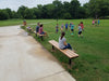 Black Wabash Valley Rinnova Recycled Plastic Backless Bench with Cedar planks, Inground mount, parents watching youth soccer from playground benches
