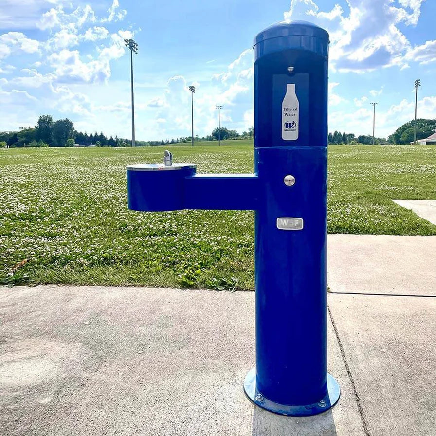 Blue Willoughby Stainless Side Approach Bottle Filler Drinking Fountain on side walk of a grassy field