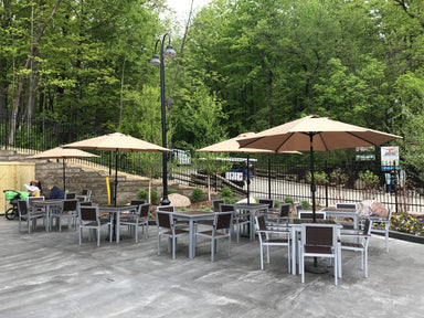Green Valley dining chairs with arms, brown slats on Silver frames, around square tables on a zoo patio, outdoor dining chairs with arms