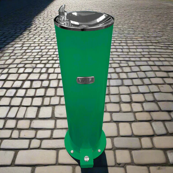 Green Willhoughby Single Outdoor Drinking Fountain with Foot Pedal on a cobblestone pavement