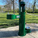 Green Willoughby Stainless Side Approach Bottle Filler Drinking Fountain in a park setting with grass and trees.