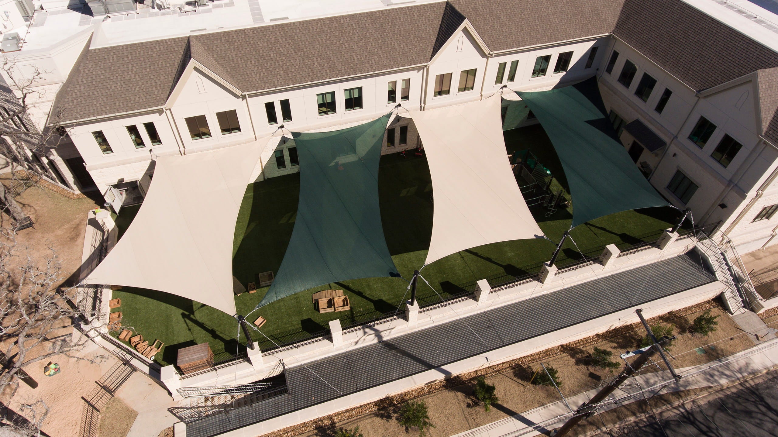Green and Tan 4-Point Hypar Sail Shades from aerial view.
