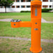 Orange Willoughby Stainless Front Approach Bottle Filler Drinking Fountain with grass and building in the background