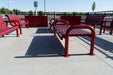 Red Wabash Valley Contemporary Slatted Steel Backless Bench Surface Mount anchored on a retail patio, commercial outdoor seating with end arms