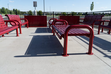 Red Wabash Valley Contemporary Slatted Steel Backless Bench Surface Mount anchored on a retail patio, commercial outdoor seating with end arms