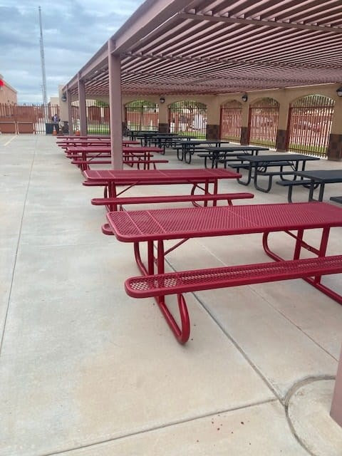 Red Wabash Valley Signature Portable Picnic Tables with Diamond tops under a shade structure in a school courtyard, outdoor school lunch tables