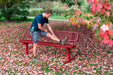 Runner stretching on a Red Wabash Valley Signature Steel Bench, Diamond seat and back, portable frame with braces, metal bench with back