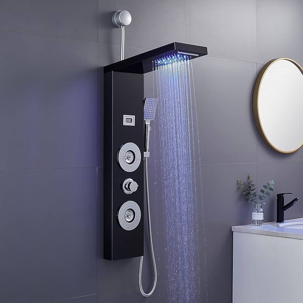Black shower panel with LED lights on a gray tiled wall in a bathroom.