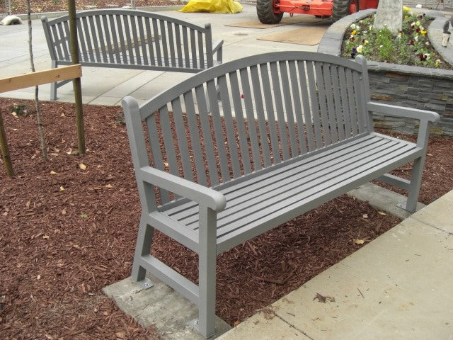 Silver Wabash Valley Arch Yorktown Aluminum Bench on a concrete pad in a mulched garden bed, model YO1213C, arched garden bench