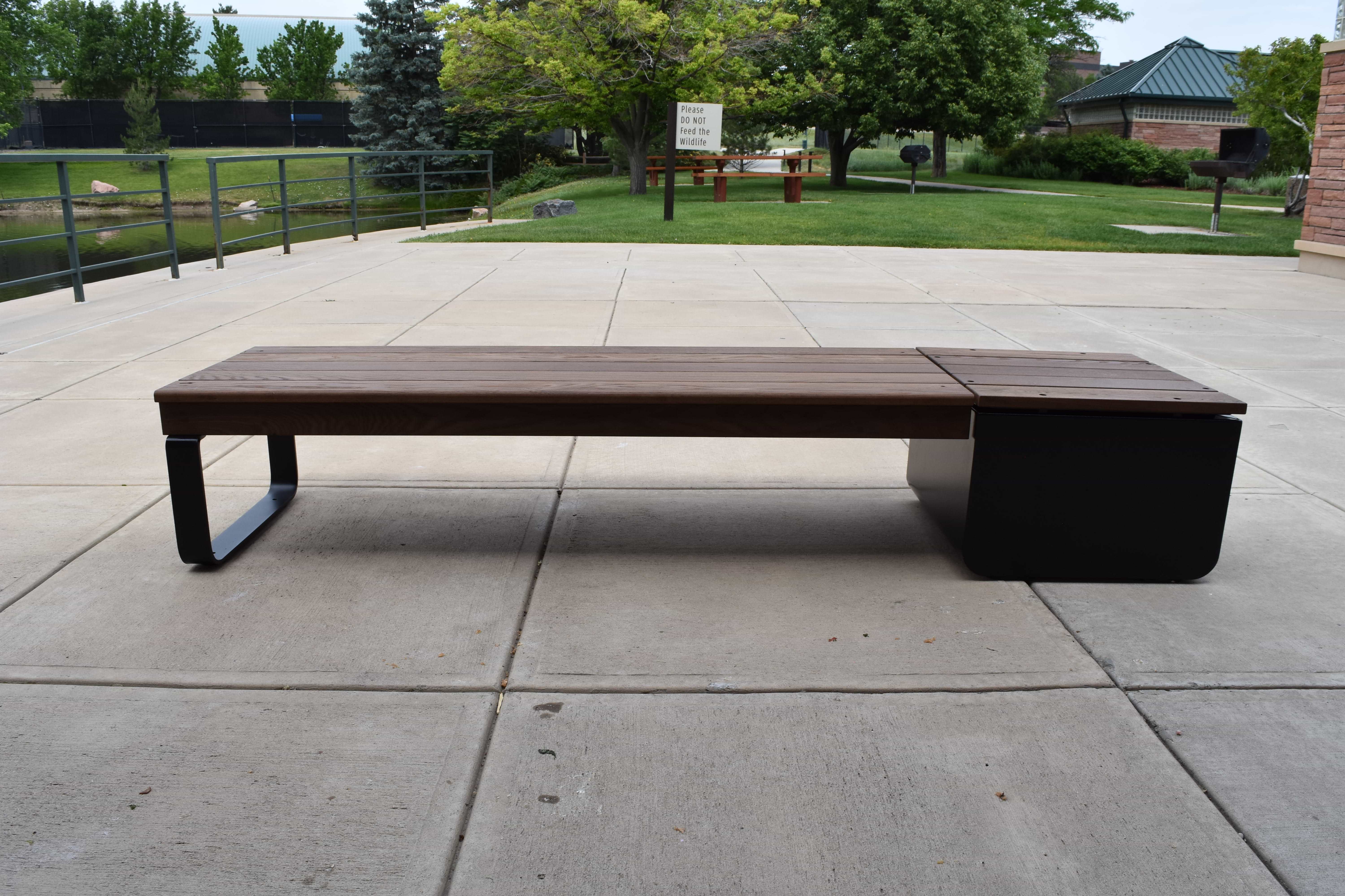 Front view of a Wabash Valley Liberty Modular Bench with Square Seat on a concrete patio, Thermory ash slats on black steel, model LBB002N, modular bench