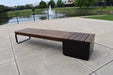 Wabash Valley Liberty Modular Bench with Square Seat on a plaza by a pond and fountain, Thermory ash slats on black steel, model LBB002N, landscape bench