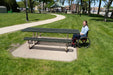 Guest in a wheelchair at the open end of a Wabash Valley Signature Portable Picnic Table, 8' ADA Accessible, green Diamond top on a tan frame, handicap picnic table