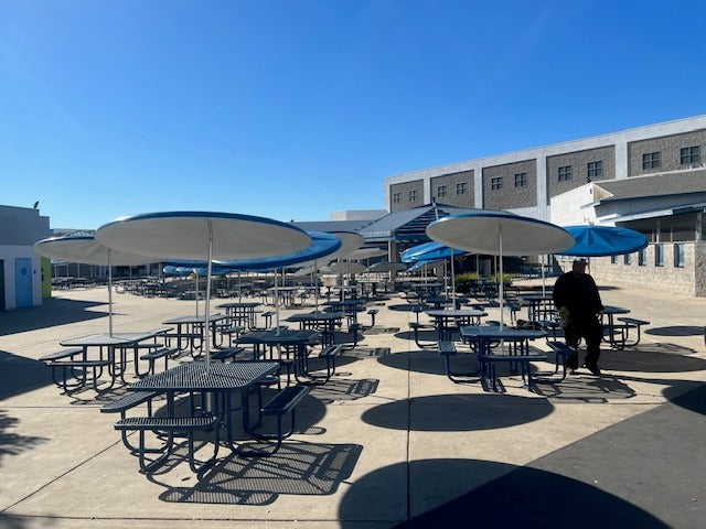 Wabash Valley Signature Square Picnic Tables with umbrellas filling a high school courtyard, 4 sided picnic tables