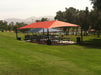 Picnic area with large red and blue USA Shade Hips on a grassy field with trees and mountains in the background.