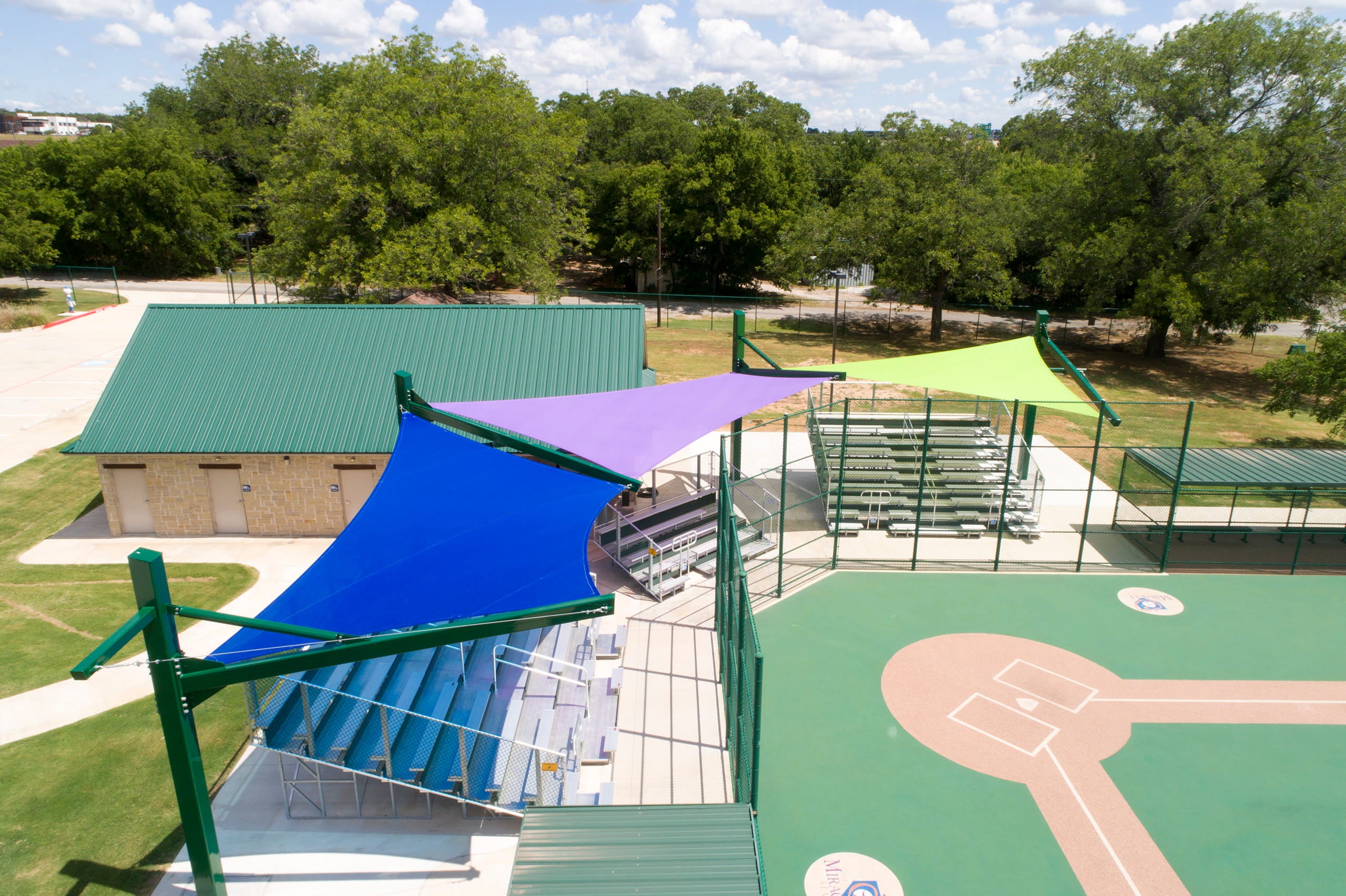 baseball field area with colorful Cantilever Hypar shade sails and green grass